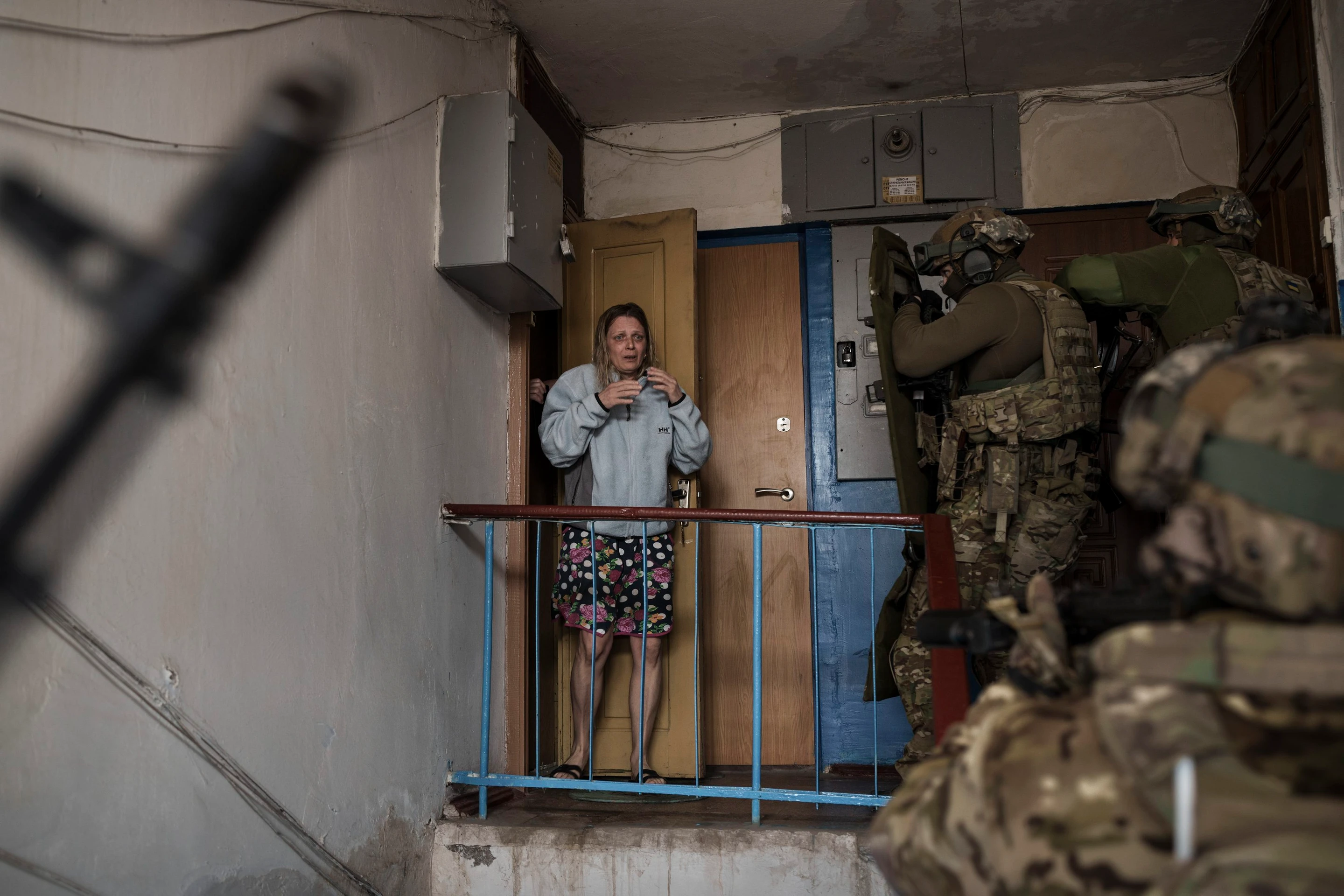 Vystrašená žena sa pozerá na príslušníkov ukrajinskej tajnej služby SBU, ktori prišli zadržať muža podozrivého z kolaborácie s Ruskom.