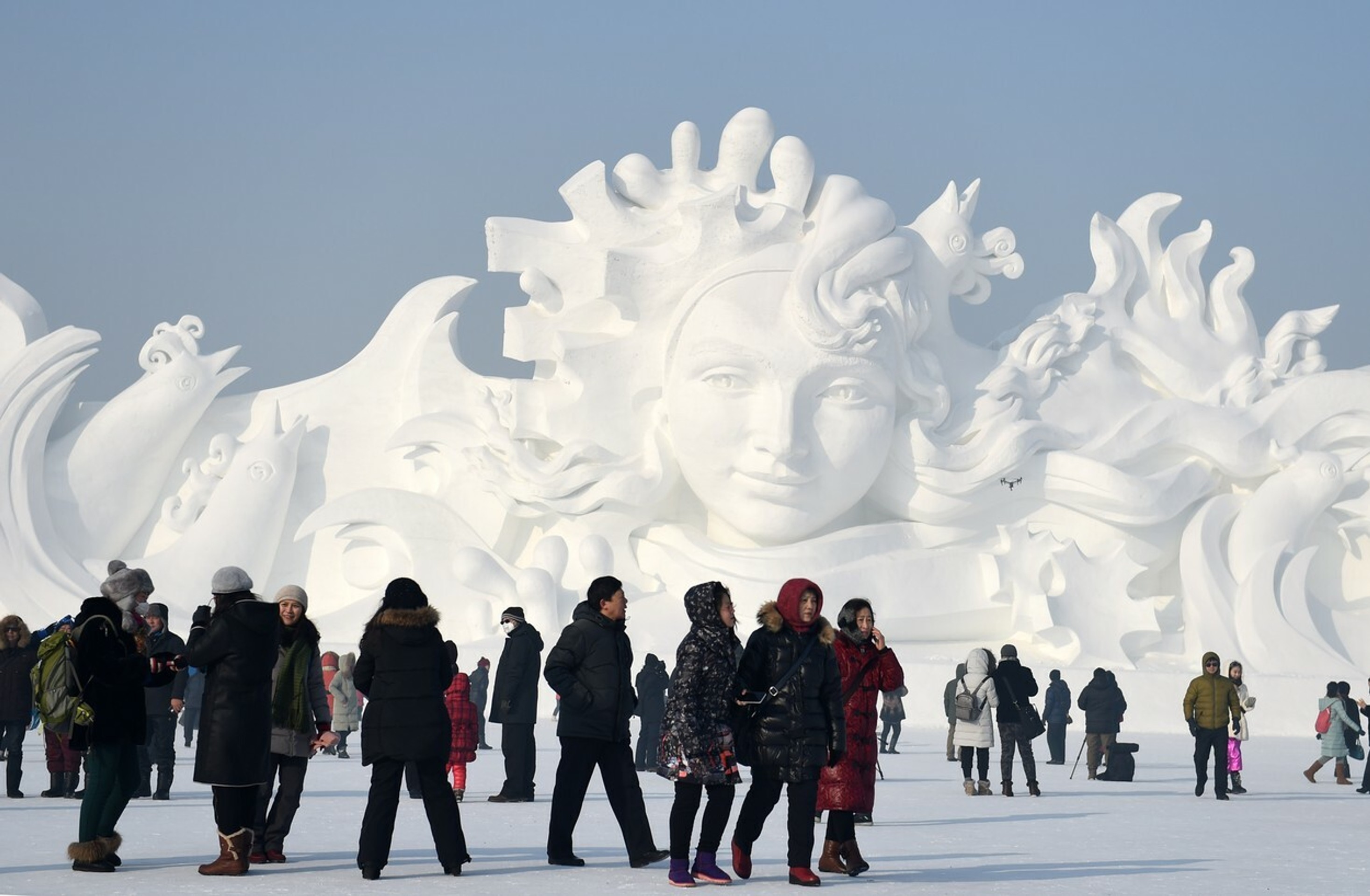 Turisti sa prechádzajú okolo snežných skulptúr, ktoré vznikli v rámci festivalu Snehu a ľadu v čínskom meste Harbin.