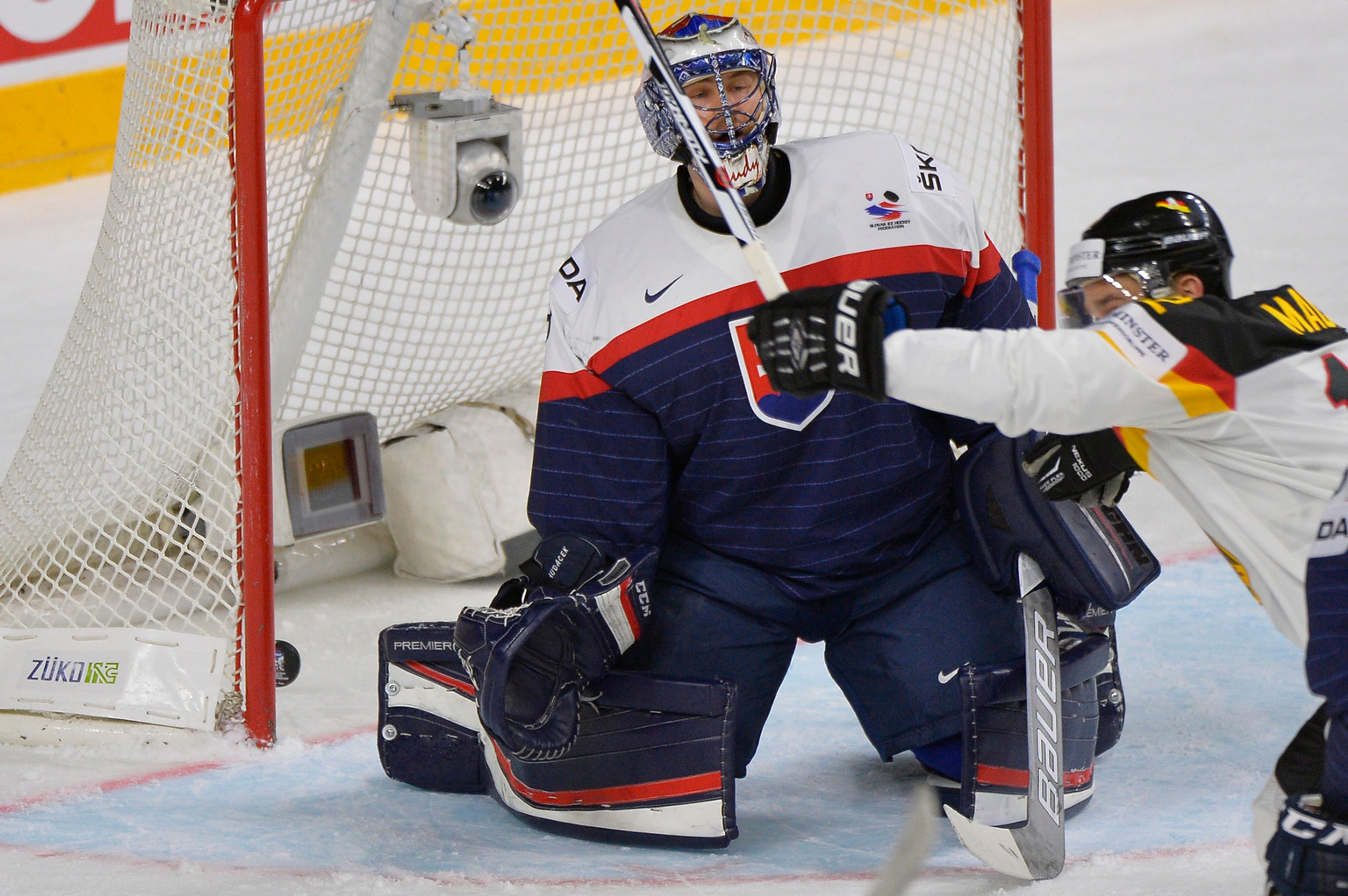 Nemecký útočník Brooks Macek číha pred gólmanom Júliusom Hudáčkom v zápase MS 2017.