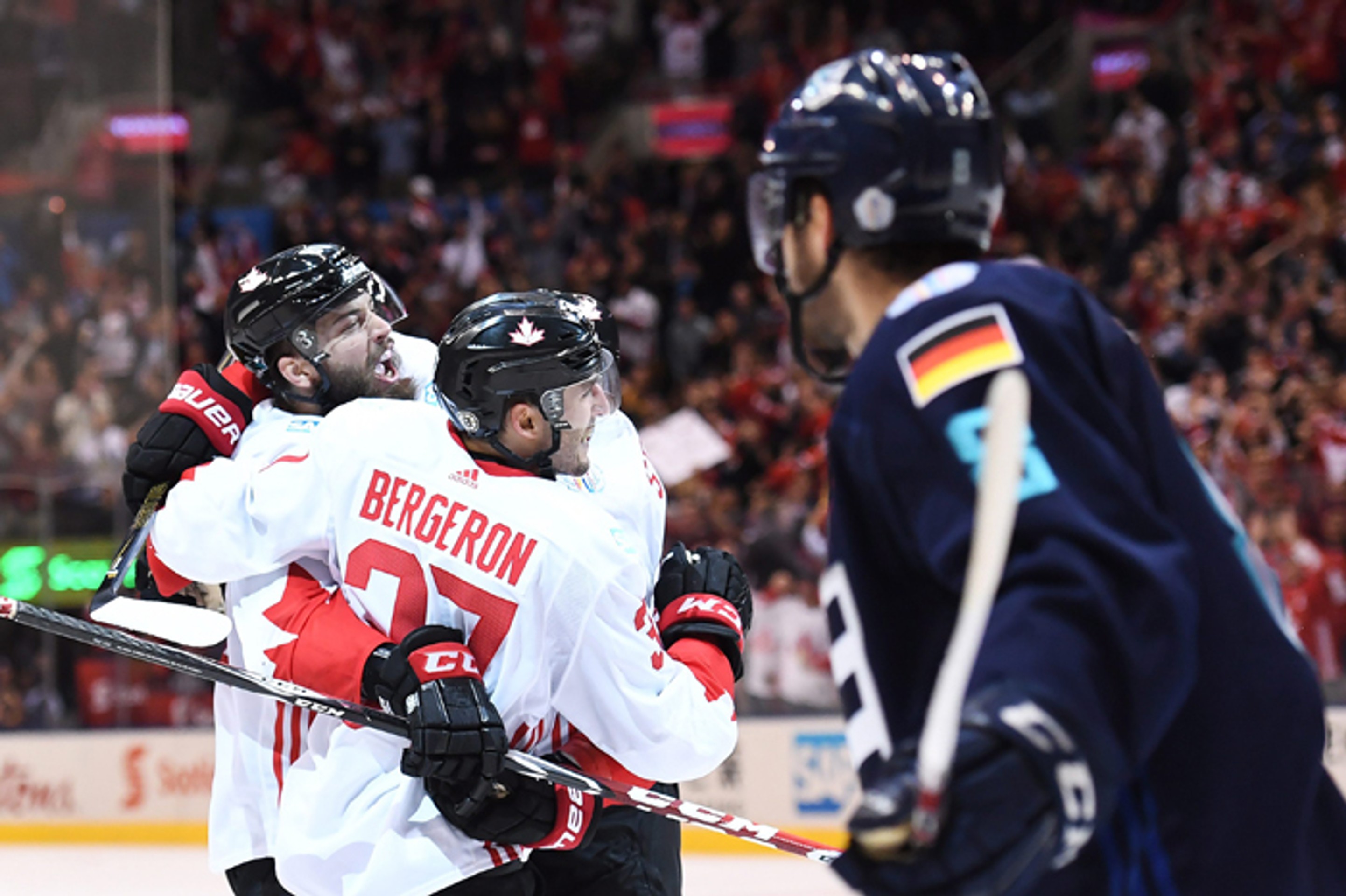 Patrice Bergeron oslavuje vyrovnávajúci gól proti Tímu Európy so spoluhráčmi Brentom Burnsom a Stevenom Stamkosom. 
