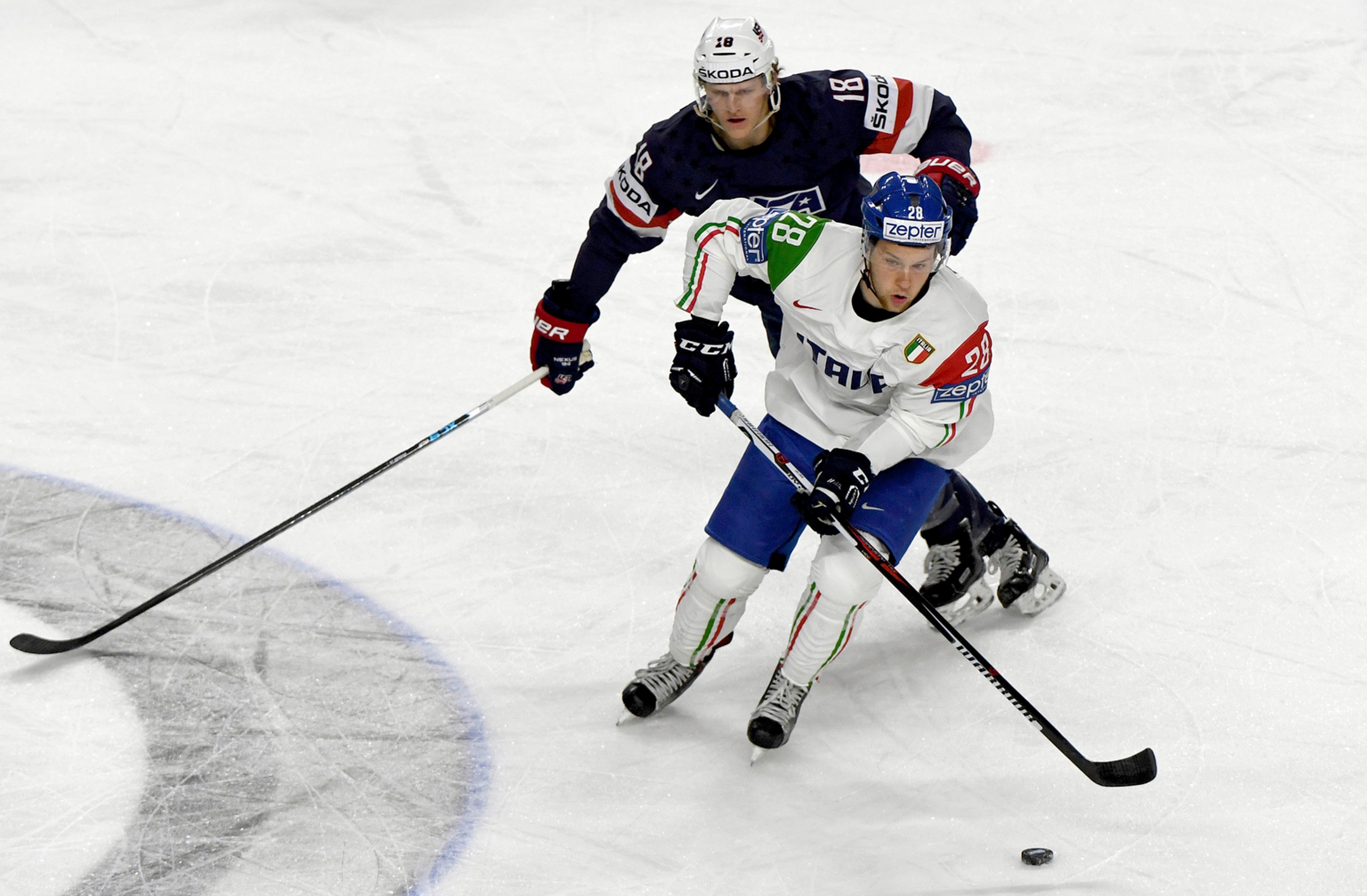 Američan Christian Dvorak (vzadu) naháňa v zápase MS 2017 Taliana Daniela Gliru.