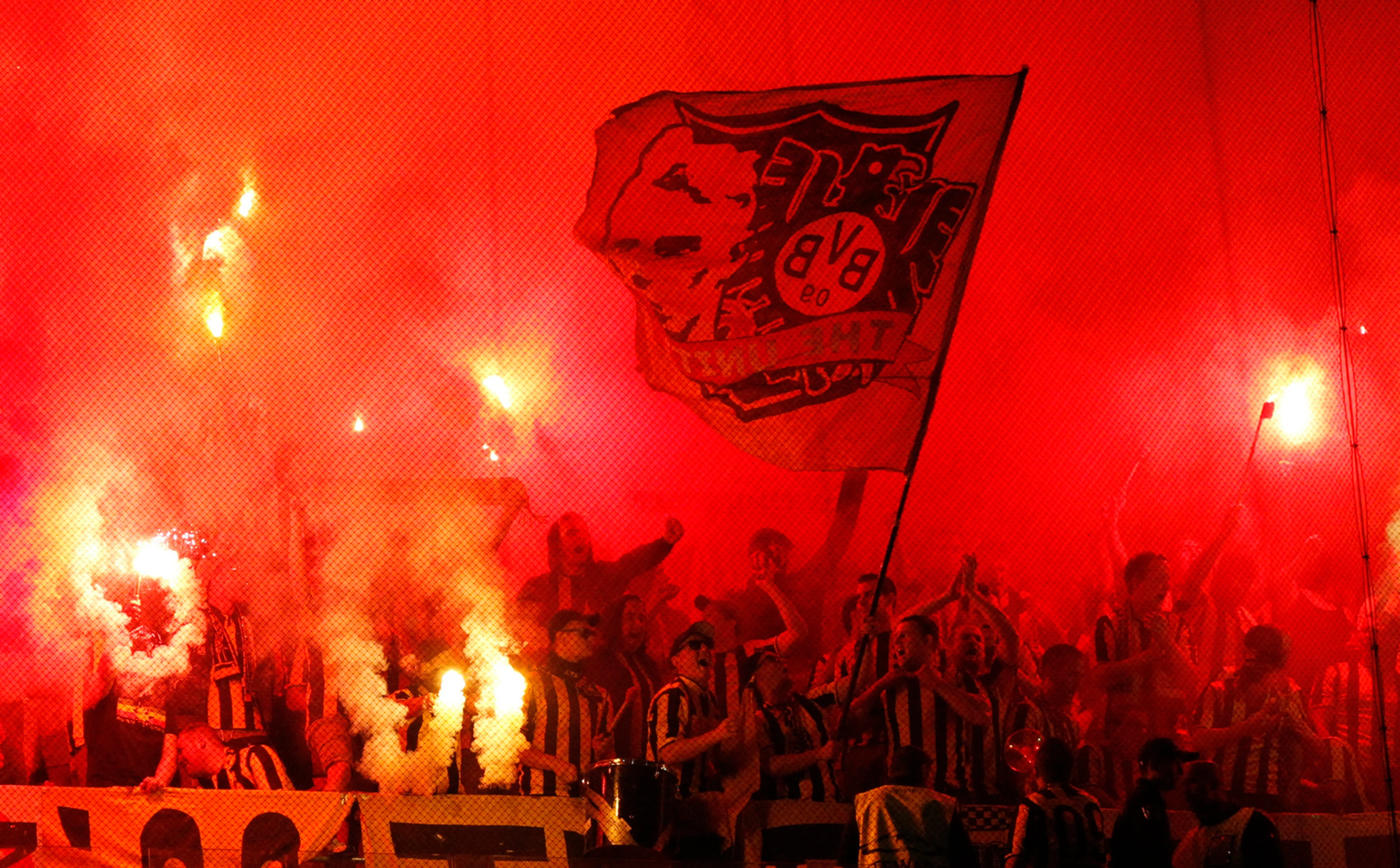 Priaznivci Dortmundu so svetlicami počas duelu LM v Lisabone proti Sportingu.