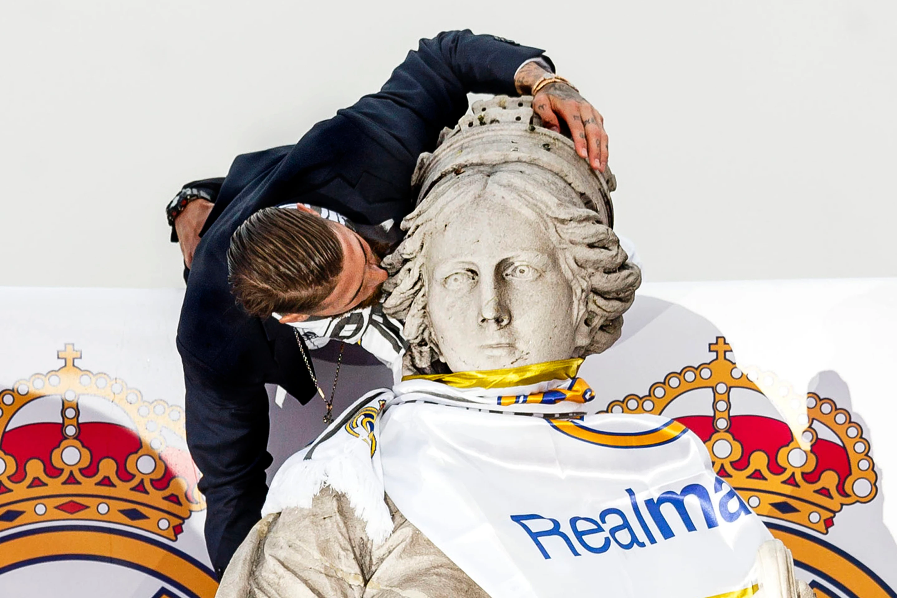 Kapitán Realu Madrid Sergio Ramos bozkáva sochu na madridskom námestí Cibeles.