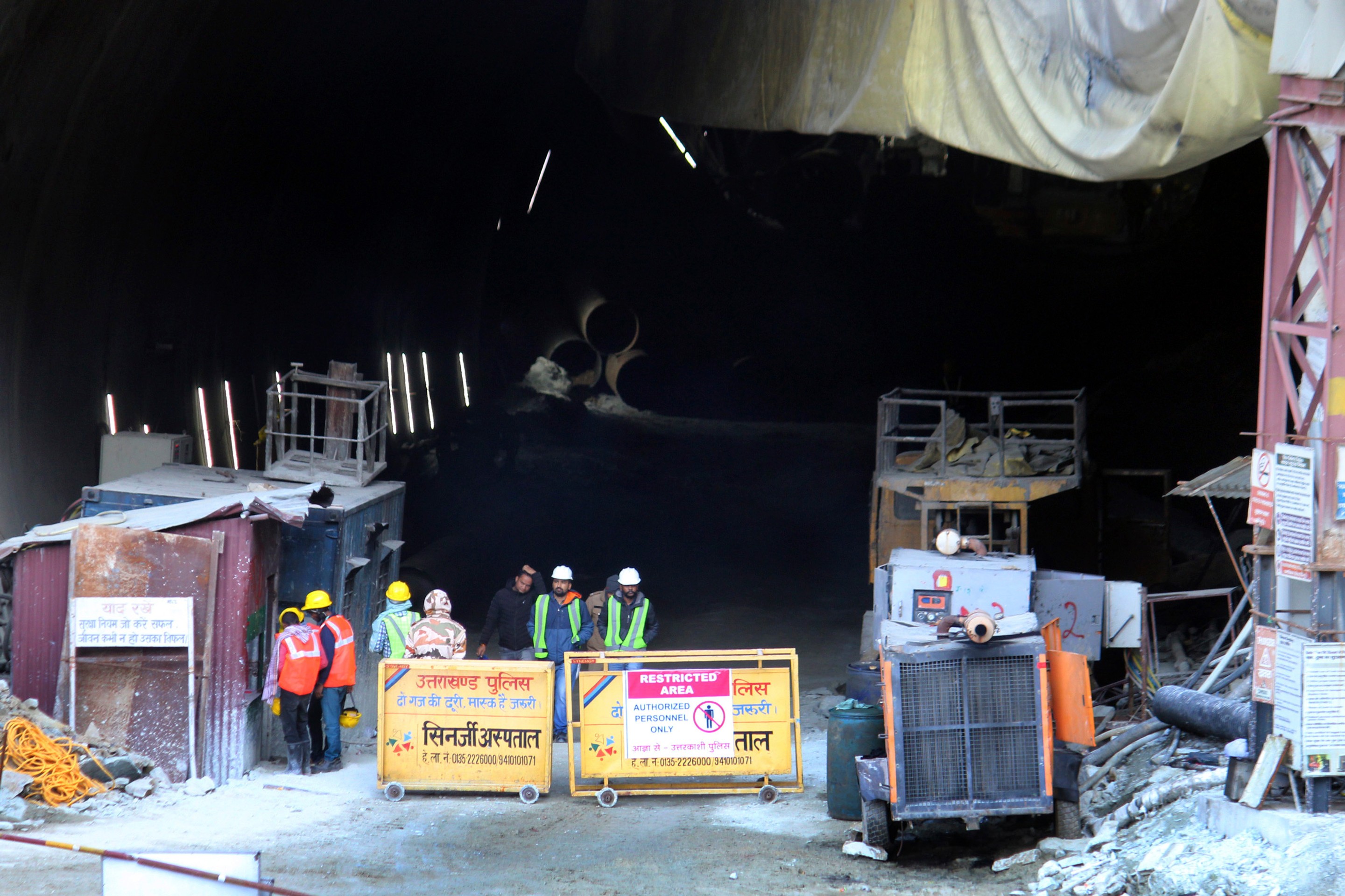 Indickí záchranári stoja pri  zrútenom cestnom tuneli, v ktorom uviazlo asi 40 robotníkov