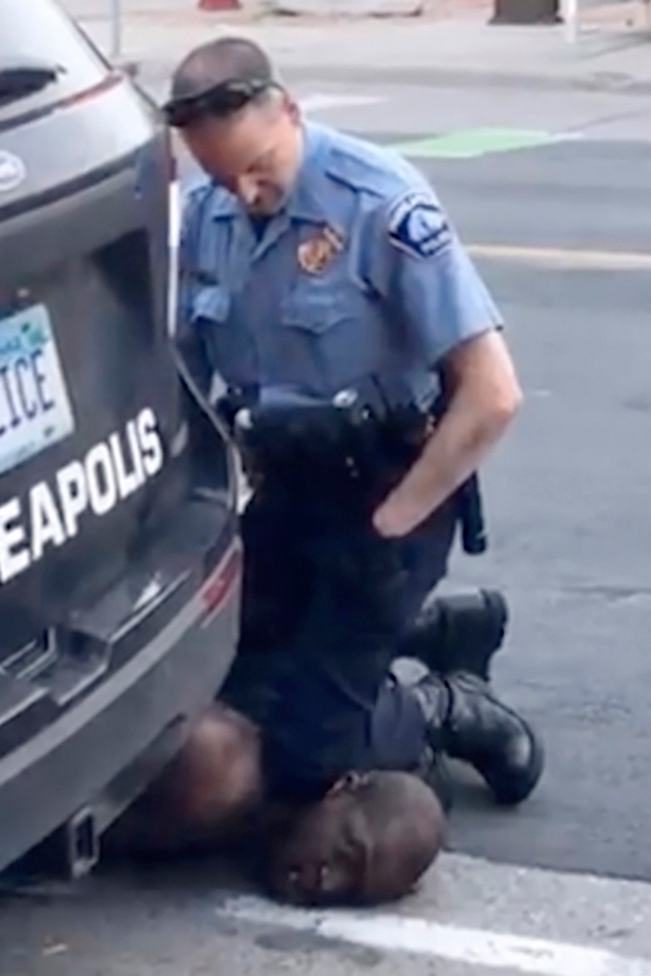Na snímke z videozáznamu policajný dôstojník v Minneapolise Derek Chauvin kľačí na krku Georga Floyda.