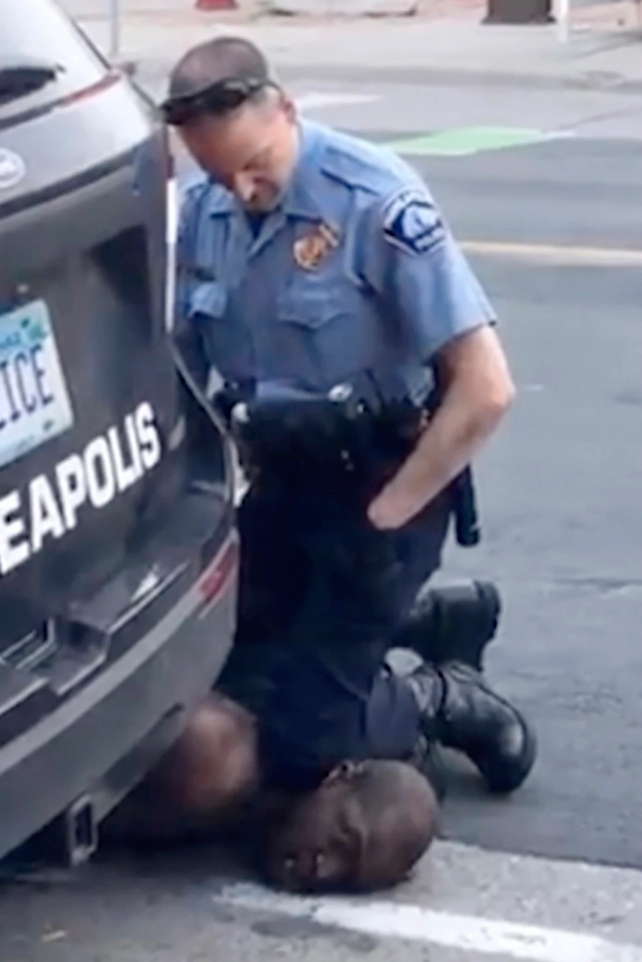 Na snímke z videozáznamu policajný dôstojník v Minneapolise Derek Chauvin kľačí na krku Georga Floyda.
